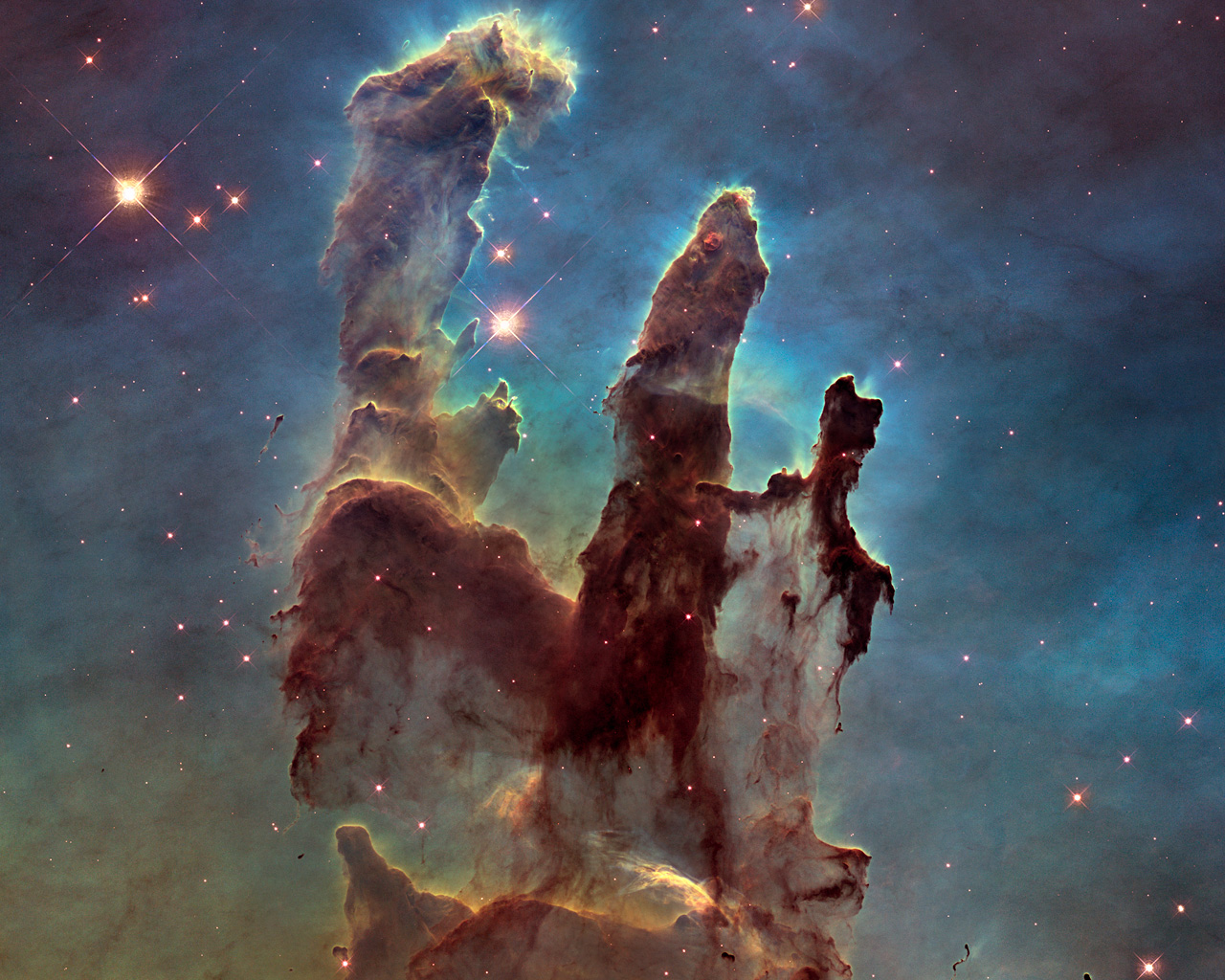 The NASA/ESA Hubble Space Telescope has revisited one of its most iconic and popular images: the Eagle Nebula’s Pillars of Creation. This image shows the pillars as seen in visible light, capturing the multi-coloured glow of gas clouds, wispy tendrils of dark cosmic dust, and the rust-coloured elephants’ trunks of the nebula’s famous pillars. The dust and gas in the pillars is seared by the intense radiation from young stars and eroded by strong winds from massive nearby stars. With these new images comes better contrast and a clearer view for astronomers to study how the structure of the pillars is changing over time.
