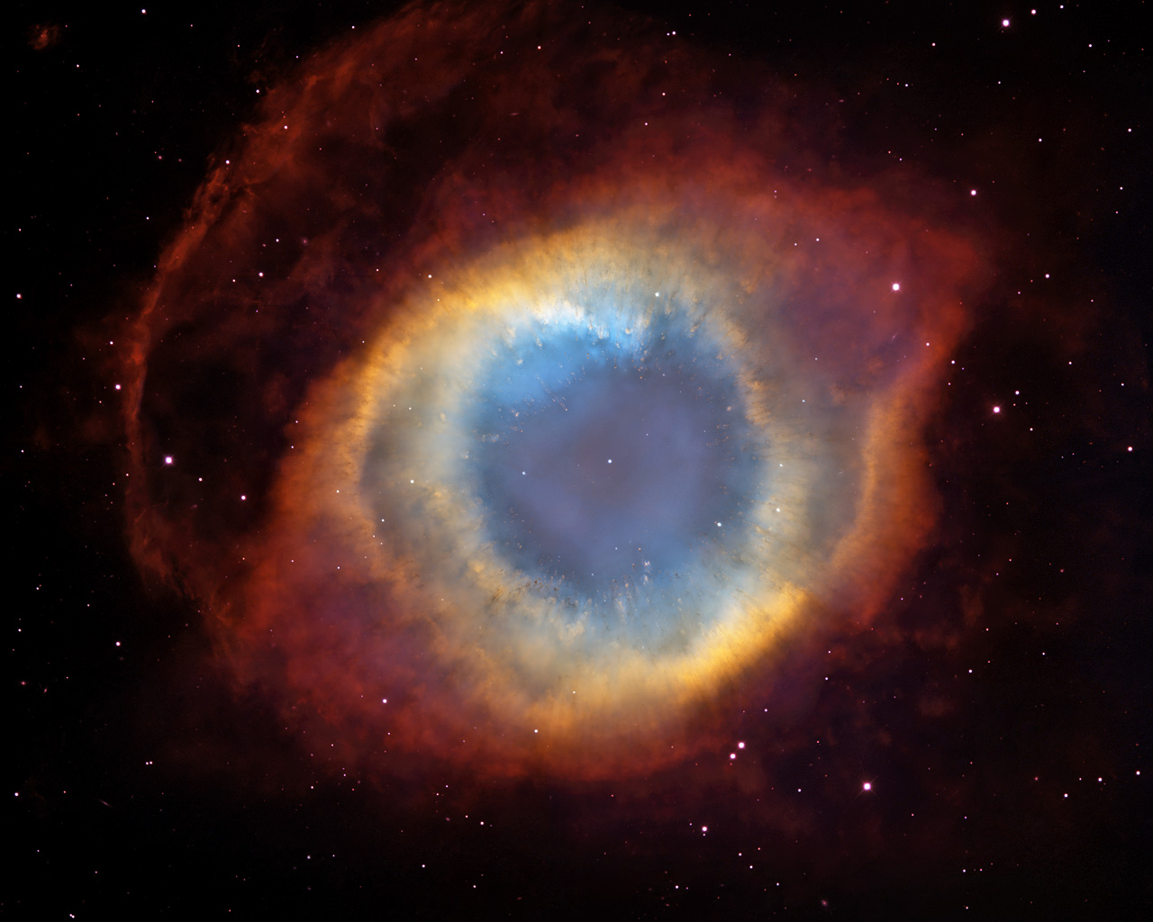 This composite image is a view of the colorful Helix Nebula taken with the Advanced Camera for Surveys aboard NASA/ESA Hubble Space Telescope and the Mosaic II Camera on the 4-meter telescope at Cerro Tololo Inter-American Observatory in Chile. The object is so large that both telescopes were needed to capture a complete view. The Helix is a planetary nebula, the glowing gaseous envelope expelled by a dying, sun-like star. The Helix resembles a simple doughnut as seen from Earth. But looks can be deceiving. New evidence suggests that the Helix consists of two gaseous disks nearly perpendicular to each other.